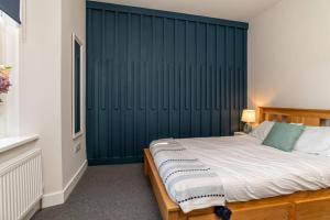a bedroom with a bed with a blue wall at * City Centre * Unique Space * in Aberdeen
