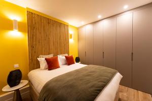 1 dormitorio con 1 cama grande con almohadas de color naranja en Au pied de la Tour, en París