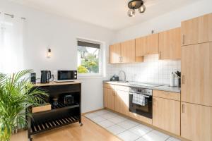 una cocina con armarios de madera y una ventana en Harmony: Edersee Apartment – Sperrmauer – Lounge, en Lago Éder
