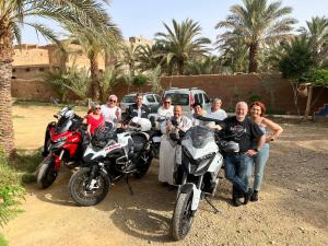 un groupe de personnes posant une photo à côté des motocycles dans l'établissement Paradis Touareg, à Zagora