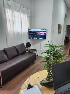 uma sala de estar com um sofá e uma mesa em Fujima Hostel em São Paulo