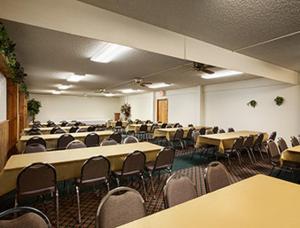 a conference room with tables and chairs in it at Super 8 by Wyndham Sturgis in Sturgis