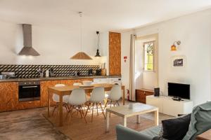 a kitchen and living room with a table and chairs at Calheta Beach House T2 in Calheta