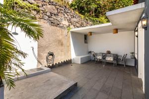 an outdoor patio with a table and chairs at Calheta Beach House T2 in Calheta