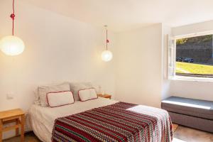 um quarto com uma cama e uma janela em Calheta Beach House T2 na Calheta