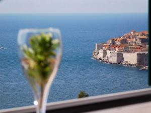 una copa de vino sentada en un balcón con vistas al océano en Apartment Precious View, en Dubrovnik