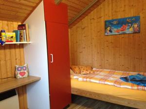 グリュックスブルクにあるFerienwohnung Michelの赤いキャビネット付きの部屋のベッド1台