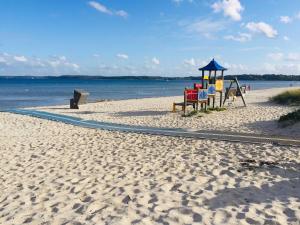 un parco giochi su una spiaggia accanto all'acqua di Ferienwohnung Michel a Glücksburg