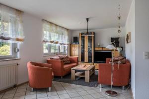 een woonkamer met oranje stoelen en een tafel bij Gutjahr in Freiamt