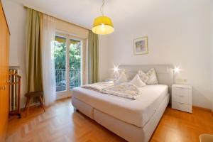 1 dormitorio con cama blanca y ventana en Villa Sabine - Edith, en Merano