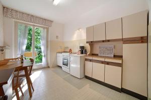 una cocina con electrodomésticos blancos y una mesa. en Villa Sabine - Edith, en Merano