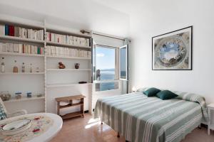 a bedroom with a bed and a window and a chair at Casa Nina in Arenzano