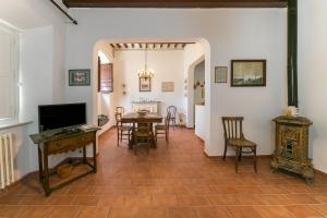 - un salon avec une table, des chaises et une télévision dans l'établissement Nell'antica dimora, à Casciana Terme