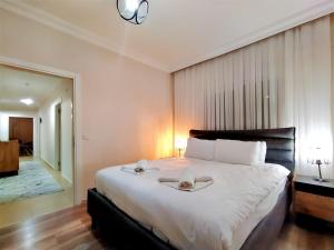 1 dormitorio con 1 cama grande y 2 toallas. en Spacious and Cozy Apartment in Muratpasa Antalya en Antalya