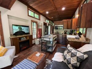 a living room with a couch and a kitchen at Snuggle Up in Broken Bow