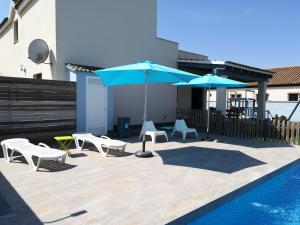 un patio con sillas y sombrillas junto a una piscina en Villa Victoria, en Cádiz