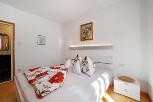 una cama blanca con almohadas en una habitación en Villa Sabine - Martha, en Merano
