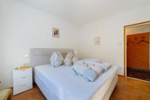 a bedroom with a white bed with pillows on it at Villa Sabine - Renate in Merano