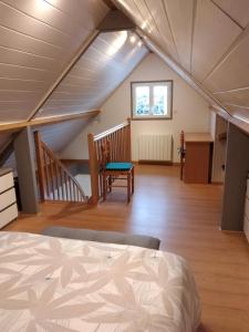 Cette chambre mansardée comprend un lit et un escalier. dans l'établissement gîte des Caves, à Civray-de-Touraine