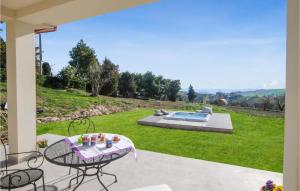 a patio with a table and chairs and a pool at Stunning Home In Appignano Del Tronto With Wifi And 4 Bedrooms in Appignano del Tronto