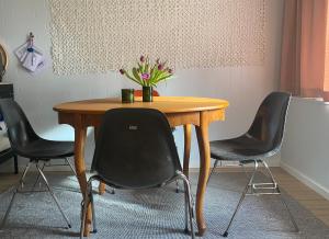 una mesa de madera con 4 sillas y un jarrón de flores en Tiny House bei Mardorf am Steinhuder Meer en Rehburg-Loccum