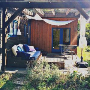 eine Terrasse mit einem Bett und einem Tisch auf einer Terrasse in der Unterkunft Tiny House bei Mardorf am Steinhuder Meer in Rehburg-Loccum