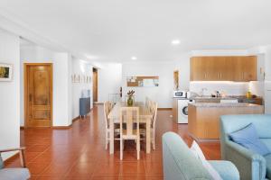 a kitchen and living room with a table and chairs at Casa Rio Contença T5 in Carvalhais