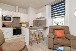 uma cozinha com um sofá, uma cadeira e uma mesa em West End @ Netflix @ Newly Built em Aberdeen