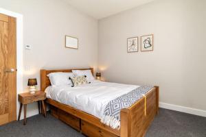 a bedroom with a wooden bed and a night stand at West End @ Netflix @ Newly Built in Aberdeen