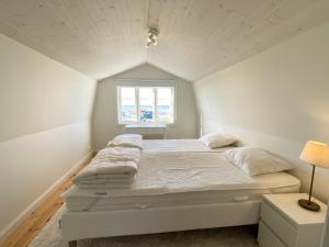 ein weißes Schlafzimmer mit einem Bett und einem Fenster in der Unterkunft Street house by Torekov harbor with sea view in Torekov