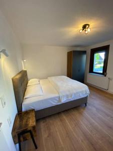 um quarto com uma cama e piso em madeira em Nisay Home - 3 Room Apartment - Nr1 em Ludwigsburg