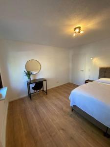 1 dormitorio con cama y mesa con espejo en Nisay Home - 3 Room Apartment - Nr1, en Ludwigsburg