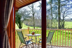a patio with a table and chairs on a porch at Secluded Pine Lodge 2 in Wigton