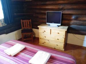 Dormitorio con cama y tocador con TV en Quechua Cabañas Funes en Funes