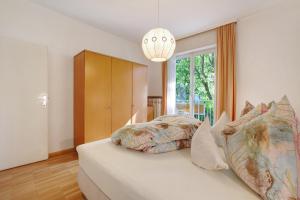 um quarto com uma cama e uma grande janela em Villa Sabine - Karin em Merano