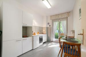 uma cozinha com electrodomésticos brancos e uma mesa e cadeiras em Villa Sabine - Karin em Merano