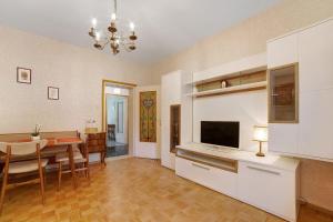 uma cozinha e sala de jantar com uma mesa e uma televisão em Villa Sabine - Karin em Merano