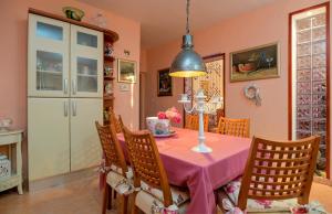 una sala da pranzo con tavolo e sedie rosa di House Aquarius a Podstrana