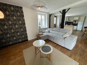 a living room with a white couch and a table at Les gîtes de Madline, Le gîte du prieuré in Saint-Georges-de-Gréhaigne +26 photos