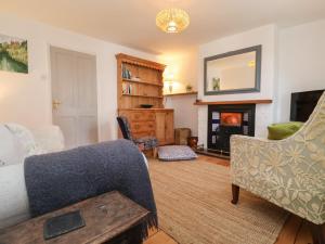 a living room with a couch and a fireplace at Victoria Cottage in Saxmundham