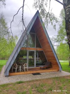 a house with a triangular roof with a table and chairs at Świronek in Białowieża