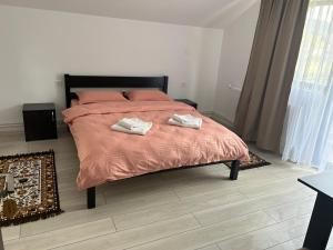 een slaapkamer met een bed met twee handdoeken erop bij Pensiunea Poiana Dornei in Vatra Dornei