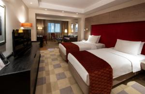 a hotel room with two beds and a television at Agaoğlu My City Hotel Istanbul in Istanbul
