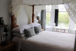 a bedroom with a bed and a table and a window at Greylands Guest House in Llandrindod Wells