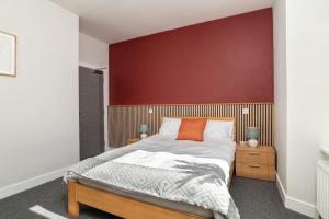 a bedroom with a large bed with a red wall at Heart of Aberdeen * Ground Floor in Aberdeen
