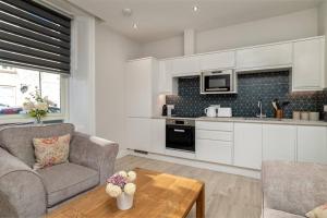 a kitchen and living room with a couch and a table at Heart of Aberdeen * Ground Floor in Aberdeen