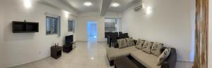a white living room with a couch and a tv at Apartment Park and Beach in Igalo