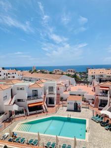 vista sulla piscina di un resort con oceano di Lux and Cozy apartment a Los Cristianos
