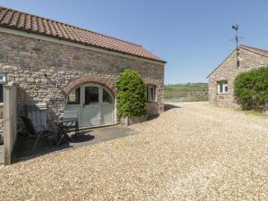 a stone house with a door and a gravel driveway at Little Wharf in Weston-super-Mare