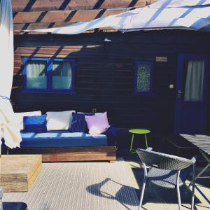 eine blaue Couch auf einer Terrasse mit einem Tisch und Stühlen in der Unterkunft Tiny House bei Mardorf am Steinhuder Meer in Rehburg-Loccum